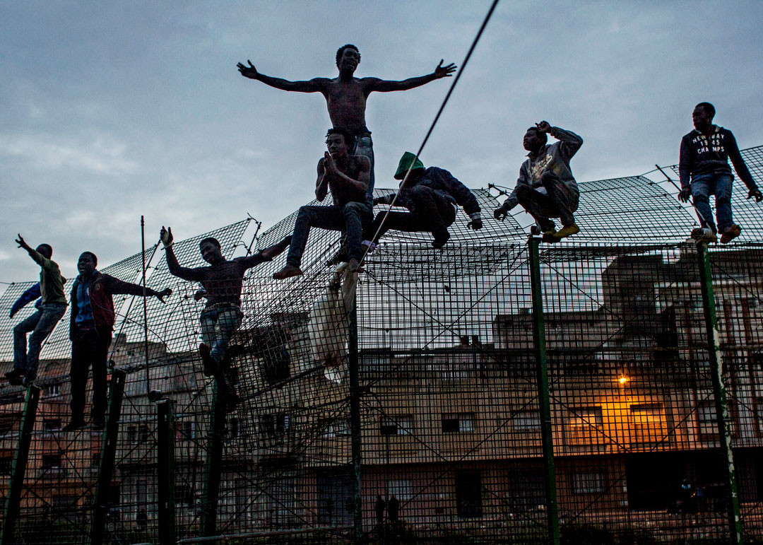 Sergi Cámara, Le Mur de l’Europe, Espagne, 2014.
							<br>De jeunes Africains tentent d’escalader la double barrière qui sépare 
								l’Afrique de l’Europe, près de Beni Enza à la frontière de l’enclave espagnole 
								de Melilla en mars 2014. Après avoir passé plusieurs heures au sommet de la 
								barrière, ils ont été refoulés vers le Maroc par les forces de sécurité espagnoles. 
								Avec l’aimable autorisation de l’artiste